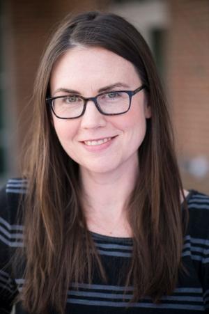 Megan Henly is a woman with long brown hair with glasses