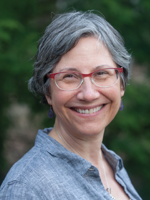 Karen Volle is a woman with red glasses and short grey hair
